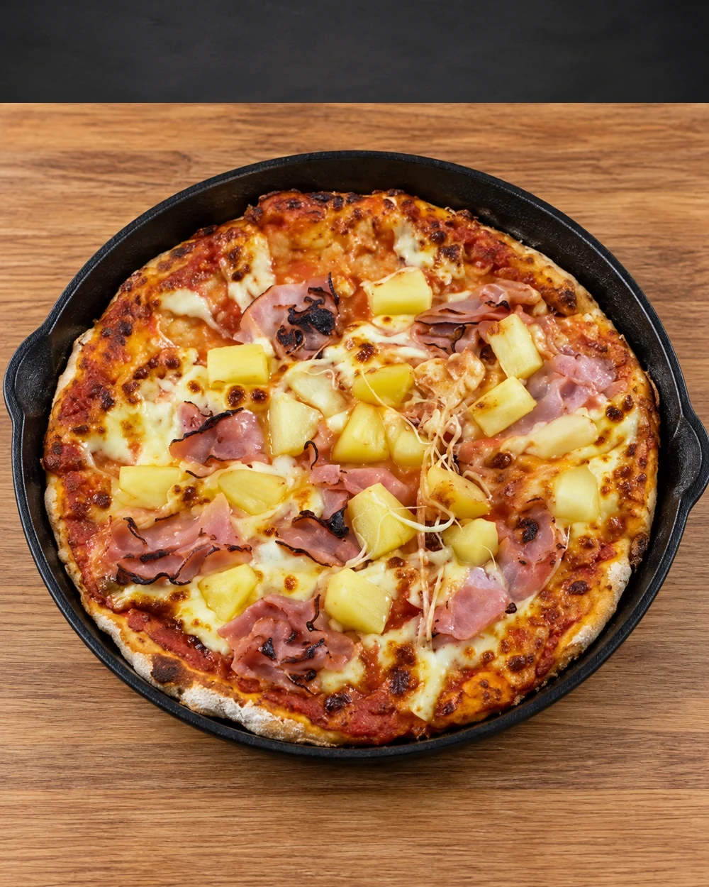 Hawaiian pizza baked in a cast-iron pan